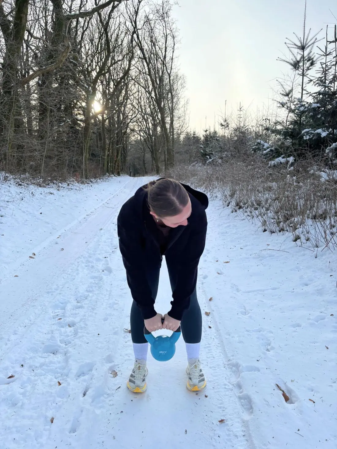 Mette tr&aelig;ner med kettlebell i sneen